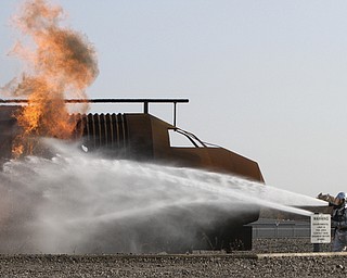 William D Lewis the Vindicator  Firefighter extinguish a blaze after a mock plane crash at Youngstown Air Force Reserve Base Monday 10-27-14. Base firefighter along firefighters from area departmentw and The Red Cross participated in the event.