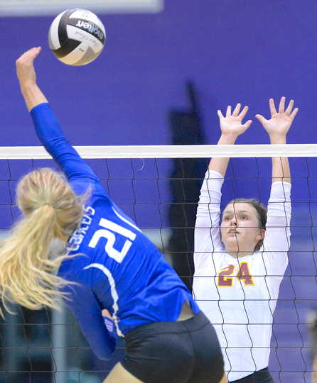Jeff Lange | The Vindicator  Mooney senior McKenzie Reese 924) puts up a defense as Gilmour Academy's Laura Brzozowski (21) puts the ball over the net during Thursday night's regional semi final match in Barberton.