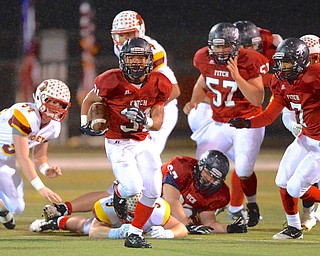 Jeff Lange | The Vindicator  Fitch's Tyler Hewlett (31) emerges from a host of Mooney and Fitch players as he runs for a gain of yards during first quarter action in Austintown, Friday night.