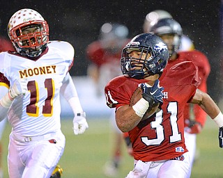 Jeff Lange | The Vindicator  Austintown's Tyler Hewlett (31) runs past Mooney defender Roosevelt Cooper (11) as he runs for a first down during first quarter action in Austintown, Friday night.