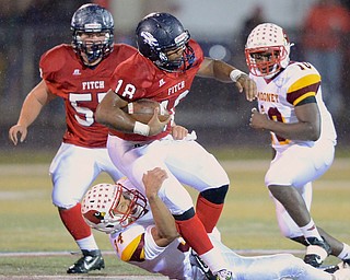 Jeff Lange | The Vindicator  Fitch's quarterback Antwan Harris (18) is brought down at the waist by Mooney's Jordan Jones (34) as Fitch's JD Vaught (left) and Mooney's Kam Stringer (right) look on from behind during first half play in Austintown, Friday night.