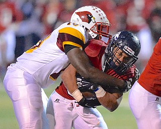 Jeff Lange | The Vindicator  Austintown's Tyler Hewlett (right) is taken down by Mooney's Kam Stringer (10) in the first quarter of Friday night's matchup in Austintown.