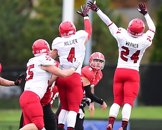 YOUNGSTOWN, OHIO - NOVEMBER 1, 2014: Hunter Wells #6 of YSU throws a pass while avoiding the pass rush from Jacob Warner #24, Ryan Hiller #4, and Sean Bredl #55 of South Dakota during the 1st half of Saturday afternoon NCAA football game at Stambaugh Stadium. YSU won 28-17. (Photo by David Dermer/Youngstown Vindicator)