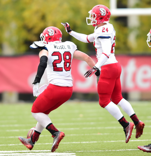 YOUNGSTOWN, OHIO - NOVEMBER 1, 2014:  John Wessel #28 is congratulated by teammate Jacob Warner #24 of South Dakota after a interception by Wessel during the 1st half of Saturday afternoon NCAA football game at Stambaugh Stadium. YSU won 28-17. (Photo by David Dermer/Youngstown Vindicator)