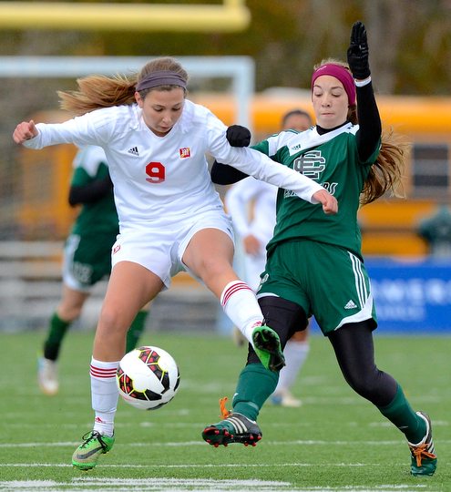 Jeff Lange | The Vindicator  Mooney's Lexy Herman (9) kicks the ball past Elyria's Anna Griffin (right) in the first half of their matchup, Saturday afternoon in Nordonia.
