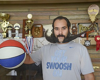 Katie Rickman | The Vindicator.Anthony Fontes poses for a photo in his Campbell home with his "swoosh" styled beard on Thursday, Oct. 30, 2014. .Fonte's has won several trophies and hopes to start a beard club.