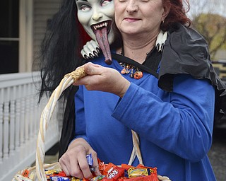 Katie Rickman | The Vindicator.Karen Price holds a basket of candy for trick-or-treaters at her hubbard home on Thursday, Oct. 30, 2014. A vampire is draped over her shoulder as she and her husband Scott pass out candy.