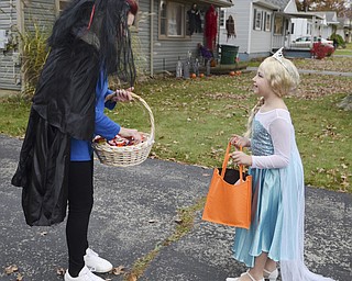 Katie Rickman | The Vindicator. Karen Price of Hubbard hands out candy at her Hubbard home to Candace Neubert, 8, who dressed up as Elsa from the movie Frozen on Thursday, Oct. 30, 2014.