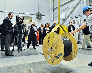 Jeff Lange | The Vindicator  Gary Hall (far right), Operations Manager for Laird demonstrates how a remote controlled crane is used, Thursday morning during a tour of the Laird facility in Warren.