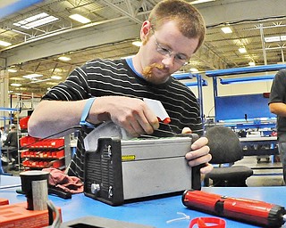 Jeff Lange | The Vindicator  Warren resident Josh Pike sprays down a paddle control box as he cleans it before taking it apart for repairs, Thursday afternoon at Laird in Warren.