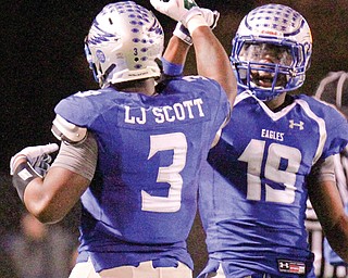 Hubbard’s Larry and Isaiah Scott bump fists after Larry scored against Canfield during their Oct. 14 game. The Eagles can become the Valley’s first public school in 15 years to win a state title.
