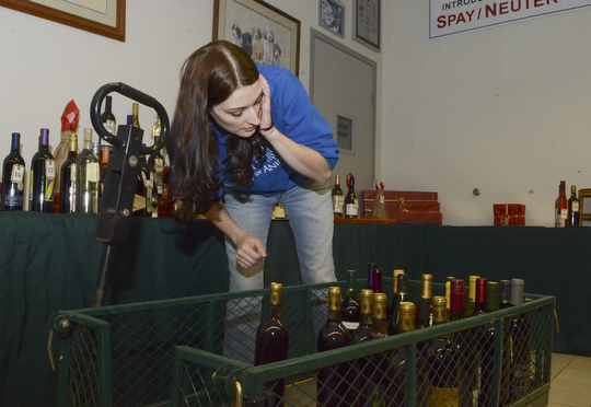 Katie Rickman | The Vindicator.Lauren Potts of Austintown, the Outreach Director for Angels for Animals organizes wine for the Wine Pull at the Wine Tasting fundraiser at Angels For Animals on Saturday, Nov. 8, 2014.