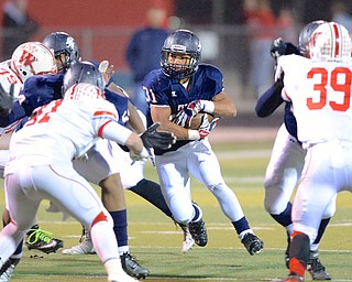 Jeff Lange | The Vindicator  Austintown's Tyler Hewlett (31) breaks through the line of scrimmage during first half gameplay in Austintown, Friday night.
