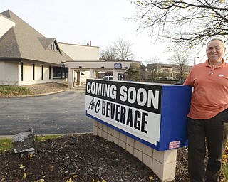 Katie Rickman | The Vindicator.Al Francischelli poses next to the sign where his business A & C Beverage will be, the building sits off to the left Tuesday, Nov. 4, 2014.