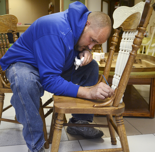Katie Rickman | The Vindicator.Adam Ruess works on a chair inside the business that he recently started with his girlfriend Ashli Zinkhon in Struthers on Nov. 5, 2014.