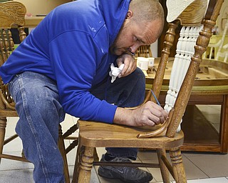 Katie Rickman | The Vindicator.Adam Ruess works on a chair inside the business that he recently started with his girlfriend Ashli Zinkhon in Struthers on Nov. 5, 2014.