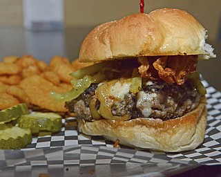 Katie Rickman | The Vindicator.The "Try It With" burger with crispy bacon, caramelized hot peppers, and romano and melted jack cheese at the Pour House Bar and Grill in Canfield...burger runs for $8.99.