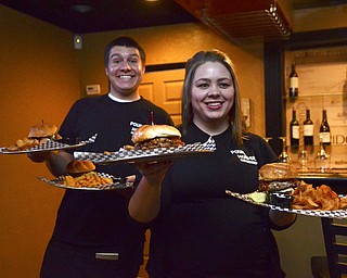 Katie Rickman | The Vindicator.Jacob Marapese of Struthers and Jennifer Peoples of Boardman serve the burgers to the guys at The Pour House Bar and Grill on Wednesday, Nov. 5, 2014.