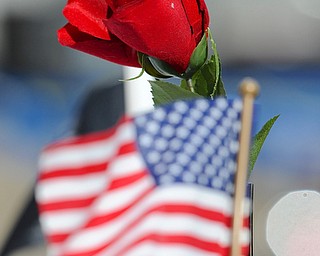 Jeff Lange | The Vindicator  A rose sits beside an American Flag on the Table of Remembrance, Sunday afternoon during the 23rd annual Laying of the Roses event in Youngstown.