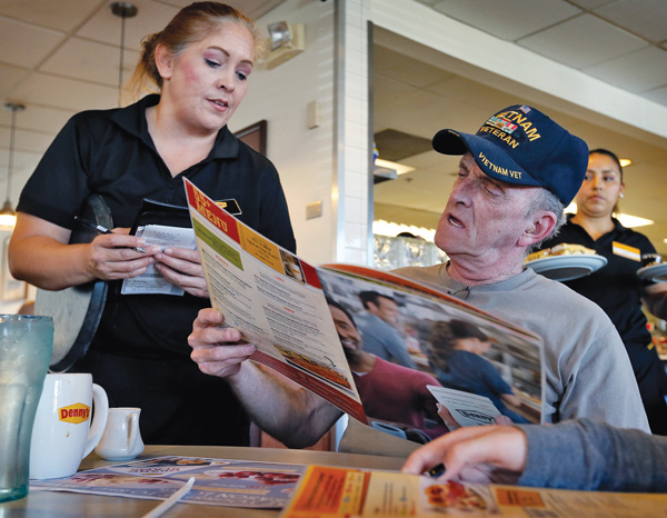 Retired U.S. Navy Vietnam veteran Larry Woodrome orders a free lunch Tuesday at Denny’s in Gilbert, Ariz. Denny’s gave away free lunches to military veterans on Veterans Day.