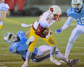 Jeff Lange | The Vindicator  Mooney's Jack Reider (23) is yanked down at the waist by Benedictine's Warren Sabba (17) as he runs during early first quarter action at Revere High School, Friday night.