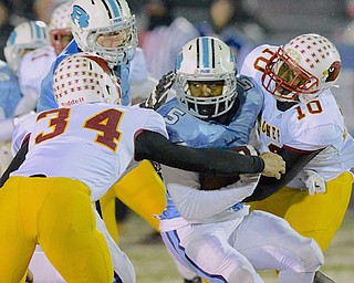 Jeff Lange | The Vindicator  Benedictine's DeCavilon Reese (5) is met in the backfield by Mooney defenders Jordan Jones (left) and Kameron Stringer (right) as they tackle him for a loss in the second quarter of Friday's regional semi final matchup at Revere High School.
