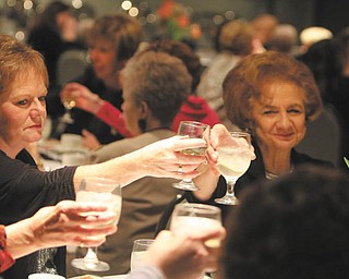 DUSTIN LIVESAY | SPECIAL TO THE VINDICATOR Sue Urmsan, left, of Mineral Ridge and Mary Lou Weingart of Salem toast their drinks during the final meeting of Yo-Mah-O Chapter of the International Association of Administrative Professionals last week at Mr. Anthony’s in Boardman.

