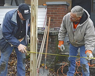 Katie Rickman | The Vindicator.Carl Dahlgren, on left of Austintown holds the measuring tape still as Pat Glasser of Boardman measures the length between posts of the the wheel chair ramp that Home Depot  volunteers built for Charles Carson, a disable Navy veteran on Friday, Nov. 7, 2014. According to Eric Thorpe, Project Cooridinator from the Salem Home Depot store, 12 volunteers total will work at the Canfield home over the two day period (Nov. 7-8).