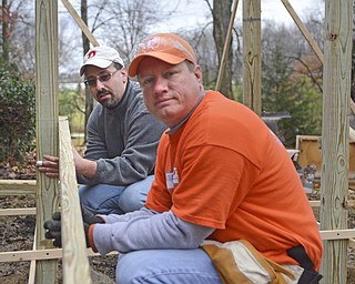 Katie Rickman | The Vindicator.Eric Thorpe of Salem (front right) and Rob Dipiero of Boardman hold the posts in place of a ramp they are building at the home of Charles Carson of Canfield who is a disabled veteran on Friday, Nov. 7, 2014.
