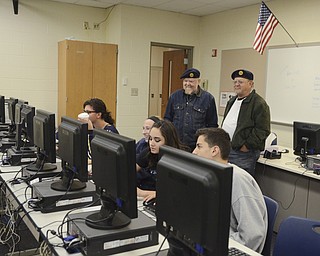 Katie Rickman | The Vindicator.Lowellville High School students (seated L-R).Starr Klenotic, 18, Abby Bowman, 16, Bella Ballone, 17, Stevin (OKAY) Vician, 17 are supervised by Everett Oliver, Commander at Lowellville American Legion and his brother Roy Oliver, Vice Commander at Lowellville American League during a planning session for the Veterans Day Program.