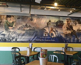 Katie Rickman | The Vindicator.A banner hangs in the patio of Quaker Steak and Lube in Austintown that depicts photos of various scenes of those who serve the military to honor those who have fought on Friday, Nov. 7, 2014.