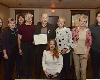 Katie Rickman | The Vindicator.David Chenowith (center) holds a certificate stating he was awarded the Purple Heart for wounds recieved while he was in the service. He is surrounded by his children and grandchildren at Enzo's in Warren on Sat. November 8, 2014..L-R.Katie Brown, Dena Brown, Karen Chenoweth, Richard Chenoweth, David Chenoweth, Amy Lovas (kneeling), Mary Chenoweth Ramba, Constance Chenoweth Davis, and Jordan Brown