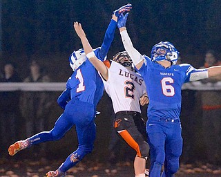 Jeff Lange | The Vindicator  Reserve's Anthony Corvine (1) and John Clegg (6) collide with Lucas WR Alex Switzer (2) as they attempt to catch a pass in the second quarter of Friday's matchup in Orrville. The Blue Devils went on to burn the Cubs in a 42-21 victory.