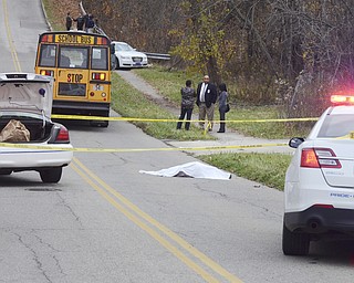 Katie Rickman | The Vindicator.The body of Faith McCullough-Wooster lies in the road where she was struck by a school bus in front of East High School in Youngstown on Wednesday, Nov. 12, 2014.