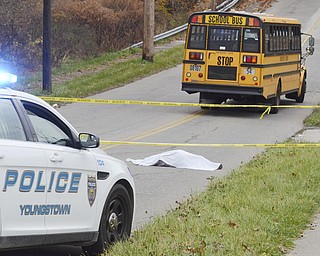 Katie Rickman | The Vindicator.The body of Faith McCullough-Wooster lies in the road where she was struck by a school bus in front of East High School in Youngstown on Wednesday, Nov. 12, 2014.