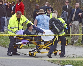 Katie Rickman | The Vindicator.A distraught parent is moved to a stretcher after daughter, Faith McCullough-Wooster, was killed after she was struck by a school bus on Wednesday, Nov. 12, 2014.