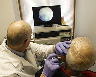        ROBERT K. YOSAY  | THE VINDICATOR..Dr. Eric Hagberg, audiologist, and patient. Hearing Innovations, .Story combines Dr. ERic HagbergÕs effort to gain equal status with chiropractors, dentists, etc. in treating his Medicare patients/ and a mission to China  .Peter Anania  gets his ears checked...by Dr Hagberg..on an annual check up- the monitor is seeing his ear drum .