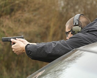        ROBERT K. YOSAY  | THE VINDICATOR..Fraternal Order of Police Lodge 141 set up this firing range for firearms training and qualification for the sheriffÕs deputies it represents off of West Ave.. B. J. Alan Fireworks donated the land and YSU donated the earth for the bullet backstops behind the targets, ..Sgt Steven Lindow... shoots  from the corner of a car in a simulation of being fired upon..and using the car for protection