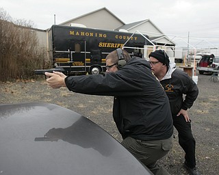        ROBERT K. YOSAY  | THE VINDICATOR..Fraternal Order of Police Lodge 141 set up this firing range for firearms training and qualification for the sheriffÕs deputies it represents off of West Ave.. B. J. Alan Fireworks donated the land and YSU donated the earth for the bullet backstops behind the targets, ..Sgt Steven Lindow..listens to instruction from firearms instructor Bob Russo