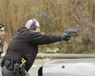        ROBERT K. YOSAY  | THE VINDICATOR..Fraternal Order of Police Lodge 141 set up this firing range for firearms training and qualification for the sheriffÕs deputies it represents off of West Ave.. B. J. Alan Fireworks donated the land and YSU donated the earth for the bullet backstops behind the targets, .Todd Mariani  fires his weapon from the corner of the car...under the direction...   firearms instructor Bob Russo