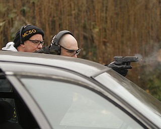       ROBERT K. YOSAY  | THE VINDICATOR..Fraternal Order of Police Lodge 141 set up this firing range for firearms training and qualification for the sheriffÕs deputies it represents off of West Ave.. B. J. Alan Fireworks donated the land and YSU donated the earth for the bullet backstops behind the targets, .Todd Mariani  fires his weapon from the corner of the car...under the direction...   firearms instructor Bob Russo