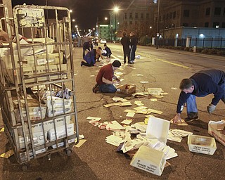 William D. Lewis the Vindicator Postal workers and concerned citizens help clean up a truck load of mail that spilled from a truck on Front St in downtown Y-town Wed. night.