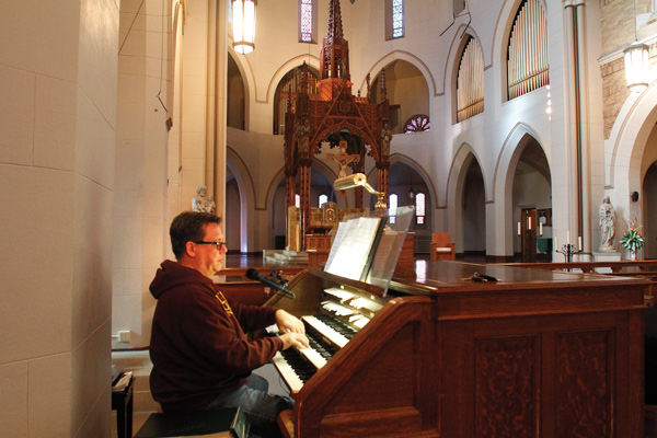 Kris Harper, music director at St. Patrick Church in Youngstown, plays the Votteler-Holtkamp-Sparling organ that was donated to the Catholic parish by John Knox Presbyterian Church, which closed last year. A dedication concert will be at 2 p.m. Sunday.