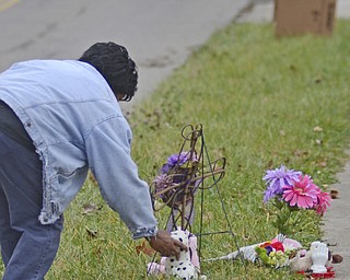 Katie Rickman | The Vindicator.Jackii (OKAY) Edwards puts a toy dog next to the make-shift memorial near where Faith McCullough-Wooster was hit by a school bus on East High Avenue on Thursday, Nov. 13, 2014.