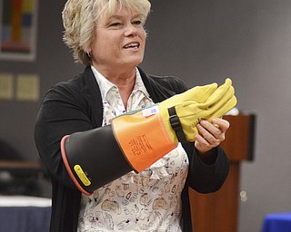 Katie Rickman | The Vindicator.Robin Kuzenko tries on a rubber glove  during a training demonstration at Kent State University Trumbull campus on Friday, Nov. 14, 2014.