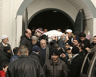  Men carry out the body of Abdullah Nagi Mahdi from the Islamic Society of Greater Youngstown on Friday, Nov. 21, 2014 at Masjid Al-Khair in Youngstown following the funeral service. Mahdi was killed earlier this week during an attempted robbery at his South Avenue store.