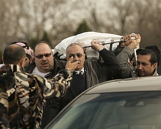 Men carry out the body of Abdullah Nagi Mahdi from the Islamic Society of Greater Youngstown on Friday, Nov. 21, 2014 at Masjid Al-Khair in Youngstown following the funeral service. Mahdi was killed earlier this week during an attempted robbery at his South Avenue store.
