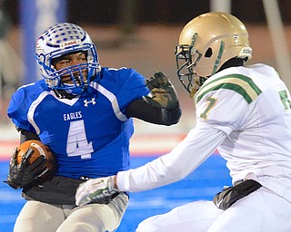 Jeff Lange | The Vindicator  Hubbard's George Hill (4) rushes around the defense of SVSM's Donte Taylor (7) during Friday night's regional final held in Ravenna.