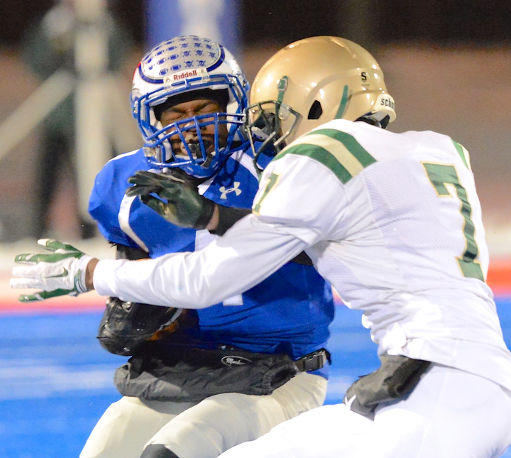 Jeff Lange | The Vindicator  Hubbard's George Hill (left) takes a hard hit from St. Mary's Donte Taylor (7) as he runs for yardage during first half action in Ravenna Friday night.