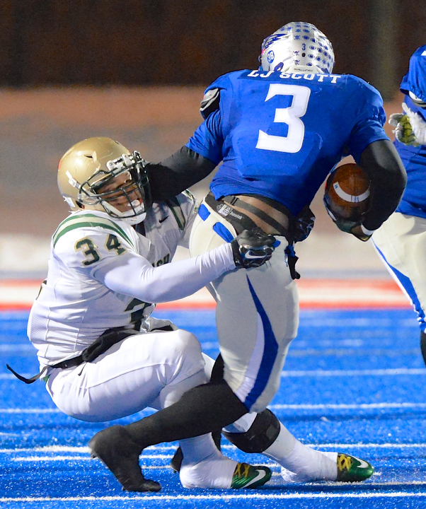 Jeff Lange | The Vindicator  Akron St. Vincent-St. Mary defensive lineman Dre'k Brumley (34) brings down Hubbard running back L.J. Scott in the backfield during third quarter action of their 26-23 victory over the Hubbard Eagles, Friday night in Ravenna.